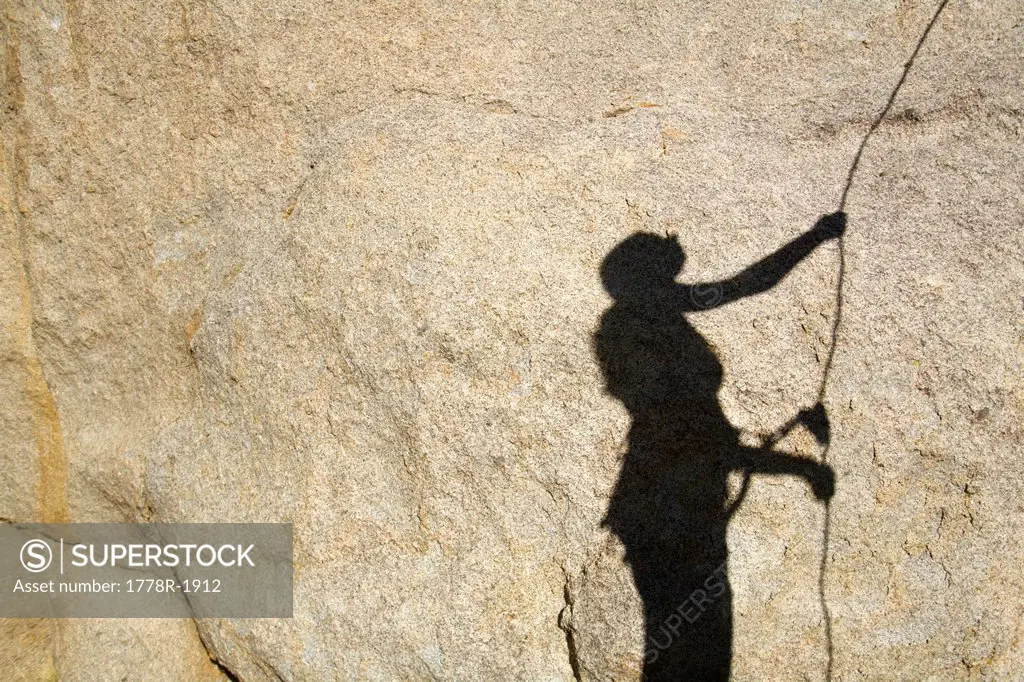 Shadow on rock of woman belaying.