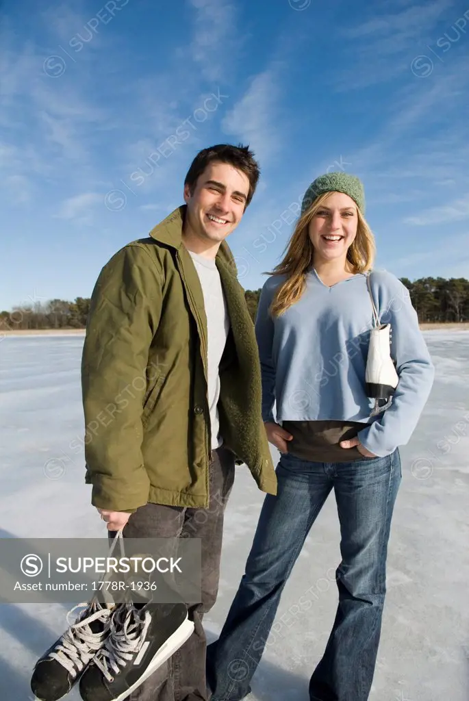 Young couple outdoors on frozen pond.