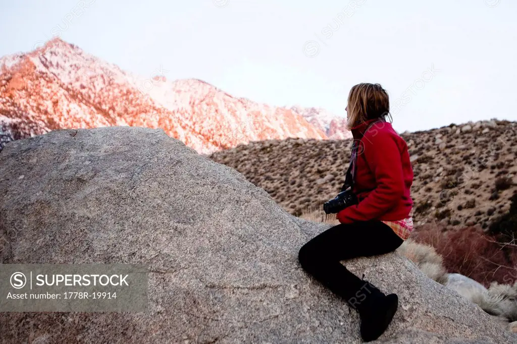A woman watches the alpine glow on Mount Whitney from a campground in Lone Pine, California.