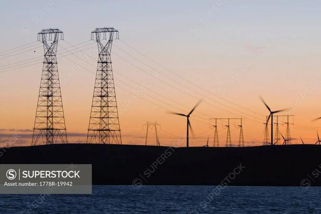 Wind turbines and power transmission lines at sunset near San Francisco