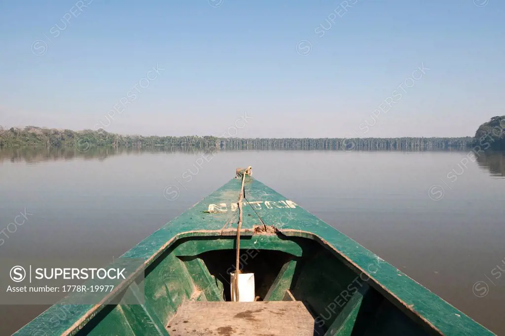 A wooden canoe made of Eucalyptus tree floats in the amazon river and connecting tributary rivers in the rainforest.