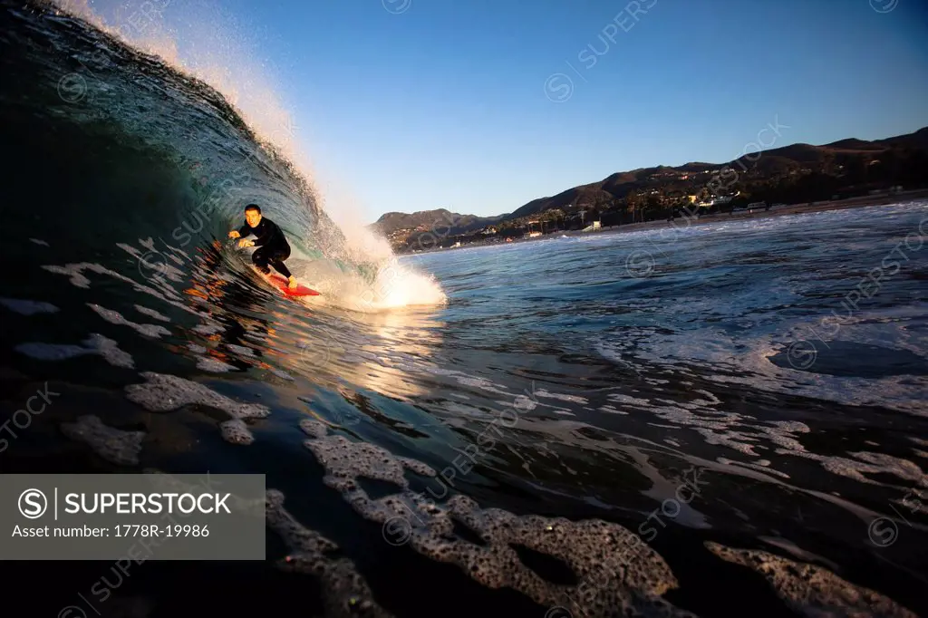 A male surfer gets barreled at Zuma beach in Malibu, California.