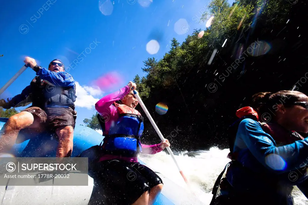 A group of adults whitewater rafting in Maine.
