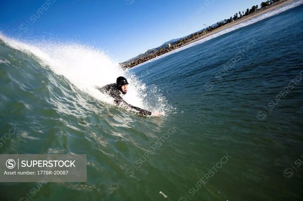 A male bodysurfer drops into a wave.