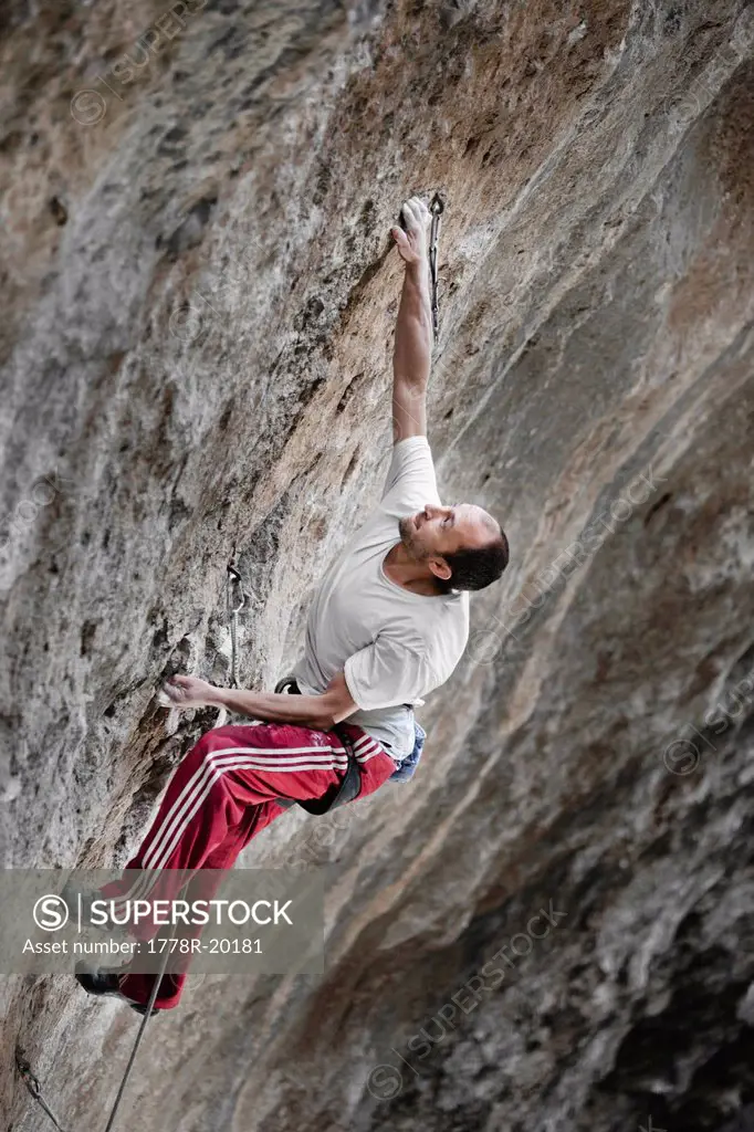 A man with white t shirt and red pants climbing in Jilotepec, Estado de Mexico, Mexico.