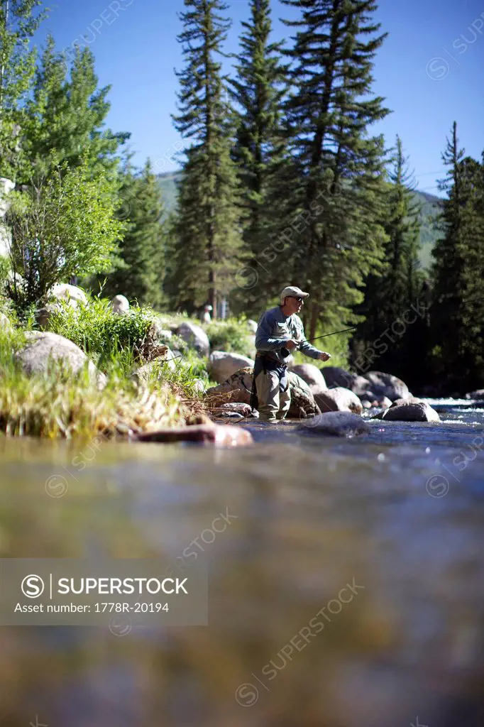 Fisherman goes fly fishing at a river in Vail.
