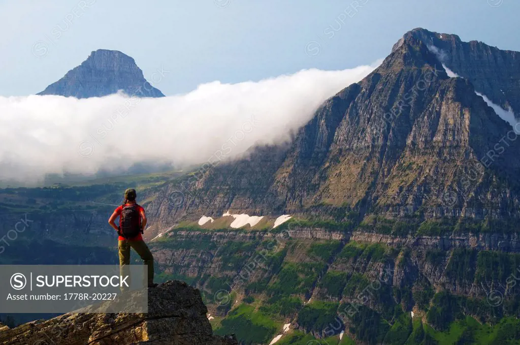 A female hiker takes in the view on the Highline Trail in Glacier National Park, Montana.