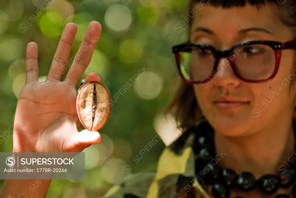 A young woman holds the seed to a relative of the African Baobab Tree.