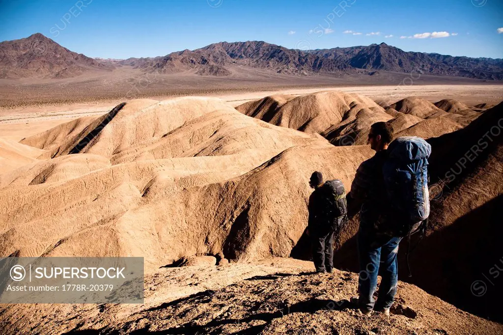 Two male hikers search to find the best route through Death Valley´s Confidence Hills, in California, while on backing packing.