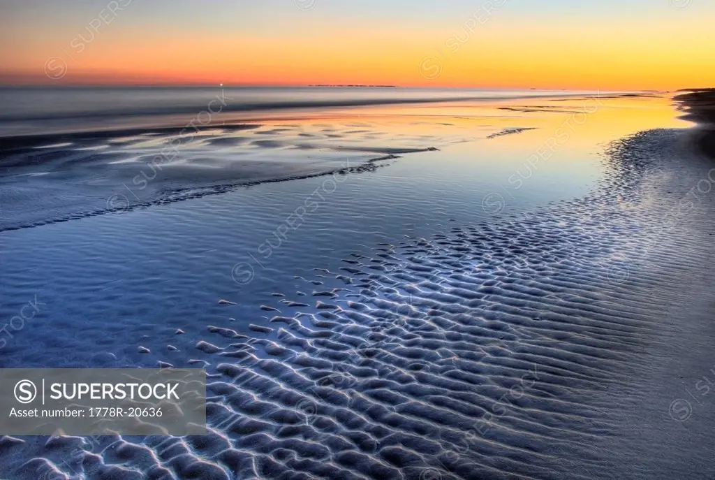 A sunset is reflected at low tide at Coligny Beach on Hilton Head Island, South Carolina.