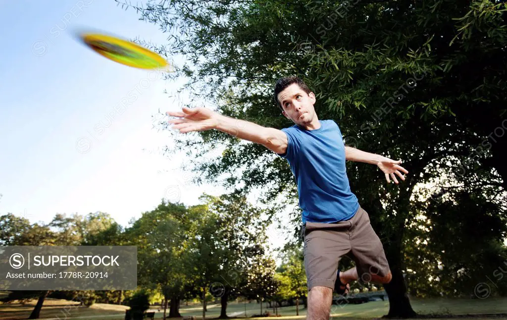 Closeup of a man making a backhanded drive playing disc golf. Motion Blur