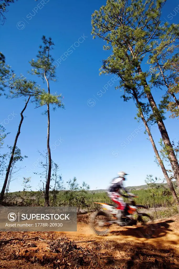 A motorcyclist rides a dirt trial on top of a hill in an Enduro race in Maplesville, Alabama. Motion Blur