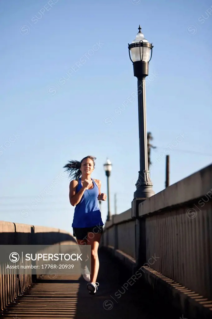 A teenage girl runs on the sidewalk of a bridge in downtown Birmingham, Alabama.