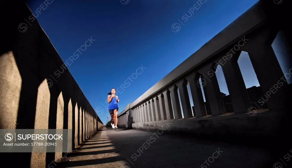 A teenage girl runs on the sidewalk of a bridge in downtown Birmingham, Alabama.