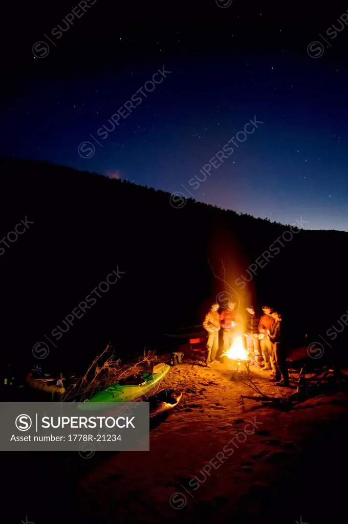 River runners huddle around the fire and swap stories during a winter river trip down the Salt River, AZ
