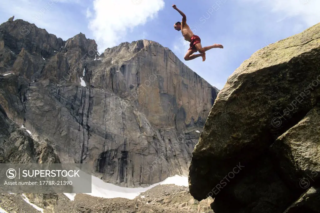 Man jumping off rock below Long´s Peak, Rocky Mountain National Park, Estes Park, Colorado.