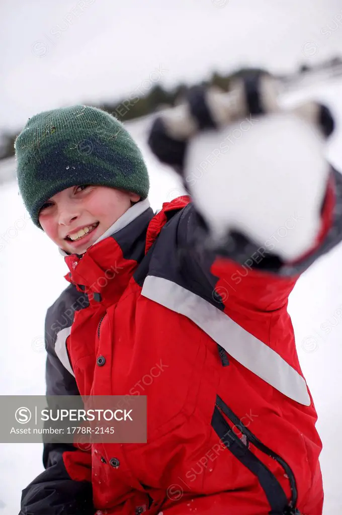 Young boy with a snowball.
