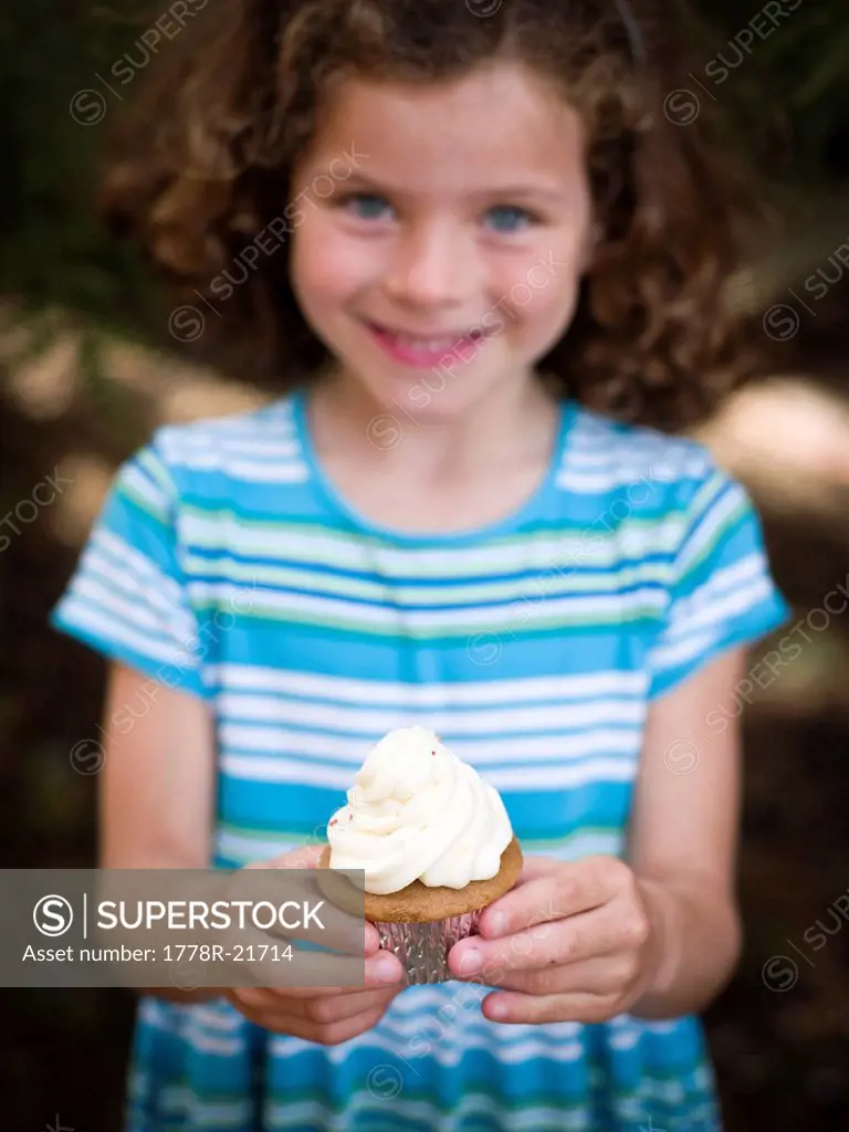 girl poses with cupcake