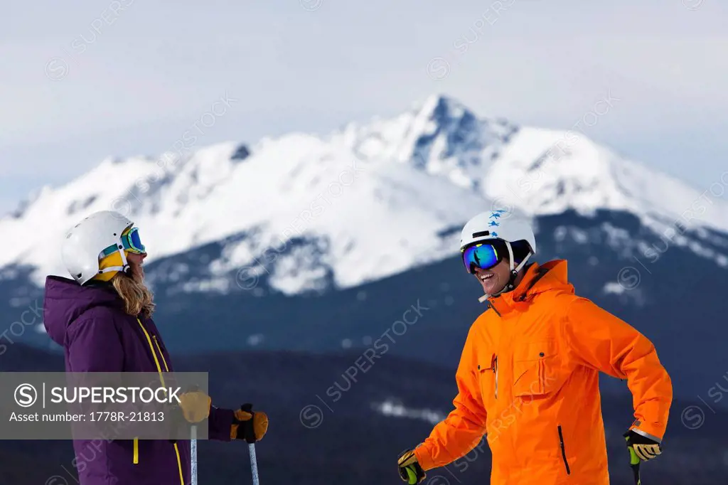 A male and female alpine skier link groomer turns on sunny day in Colorado.