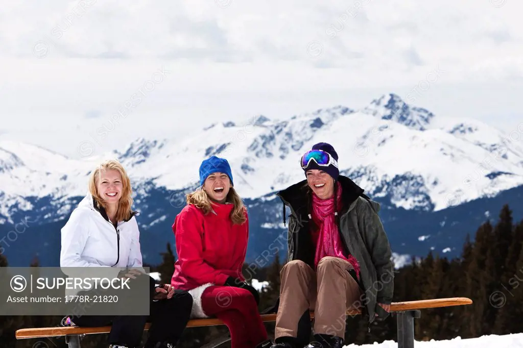 Three beautiful women laugh and smile while enjoying a fun ski day in Colorado.