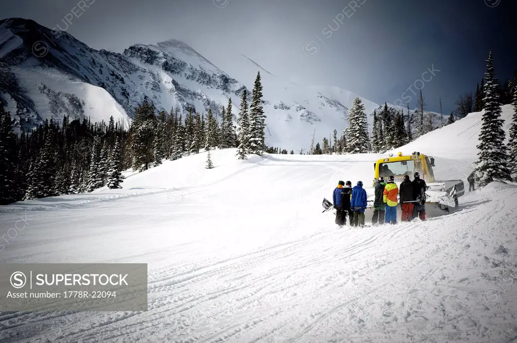 Skiers ride up to the top of a terrain park with a snow cat in Montana.
