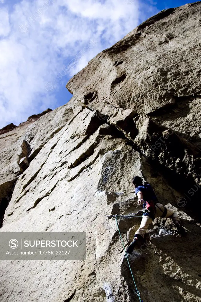A rock climber makes his way through a difficult section of a climb.