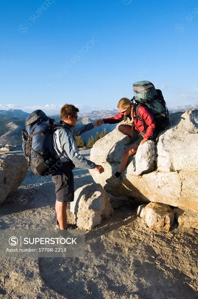 Hiker being helped off of rock.