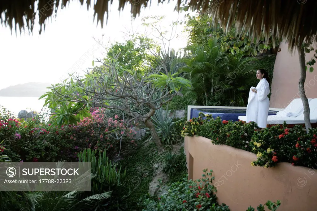 A woman stands an a terrace at a hotel in Mexico.