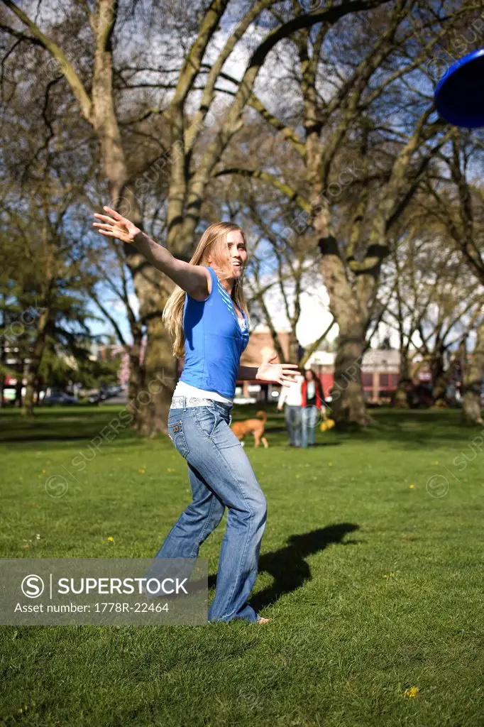 SEATTLE, WASHINGTON. A young woman throwing a frisbee in the park.