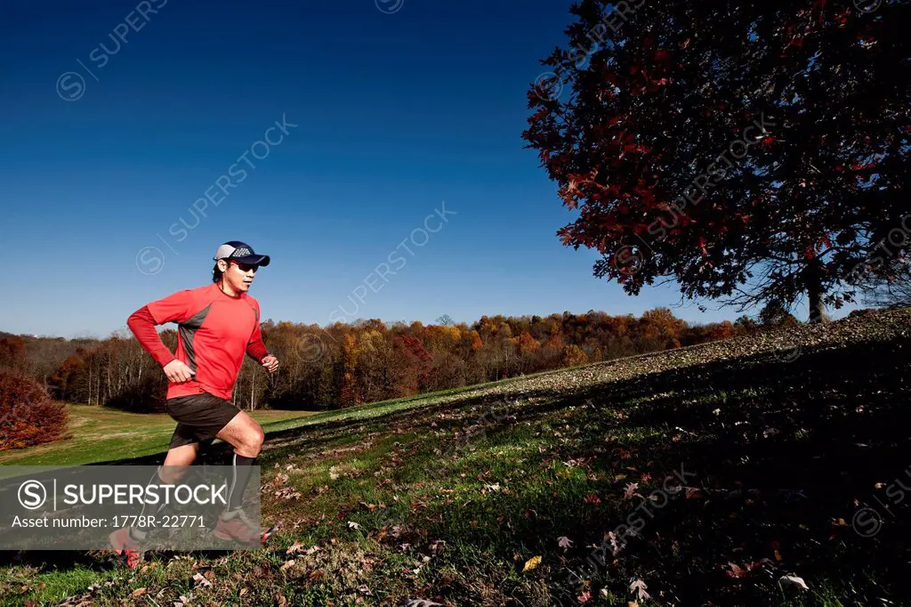 A man runs up a hill in a park