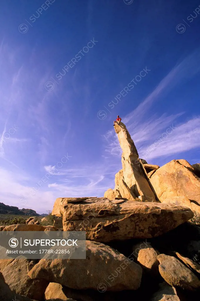 A man sits atop the Aiguille de Josh in the Lost Horse Valley area of Joshua Tree National Park, CA