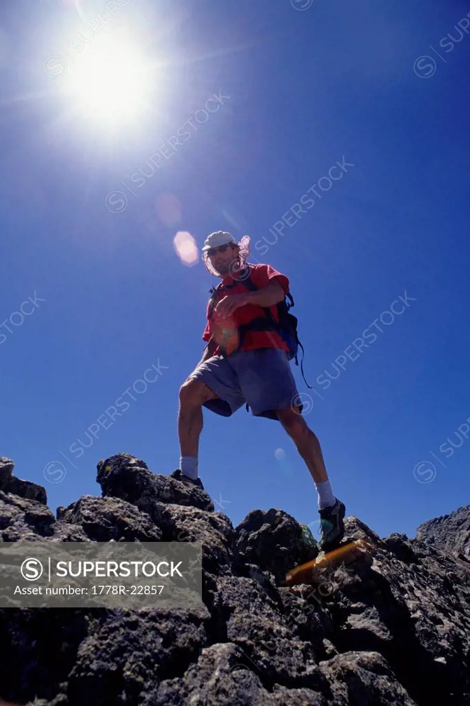 A hiker balances along the ridge between Little Bear and Blanca Peaks in the Sangre De Cristos Mountains of CO