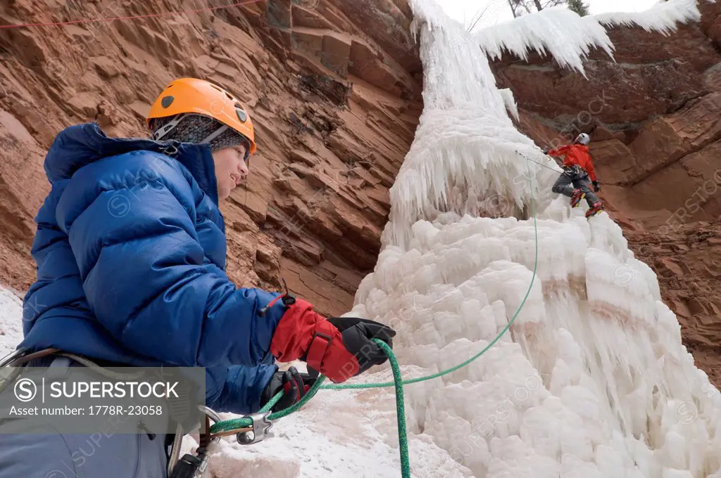 Two men ice climbing up an ice pillar, San Juan National Forest, Durango, Colorado.