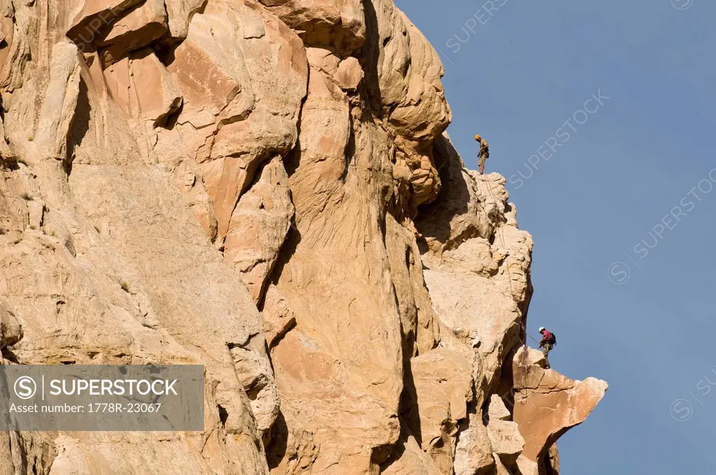 Two men rock climbing a sandstone prow in the San Rafael Swell, Green River, Utah.