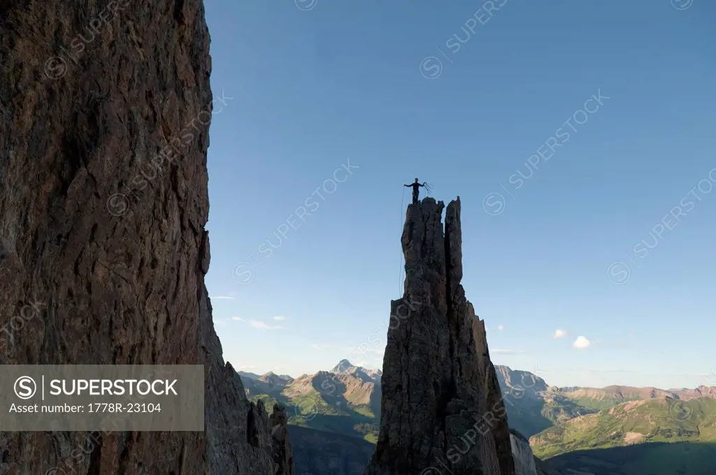 A man standing on rock spire in the White River National Forest , Marble, Coloradosilhouette.