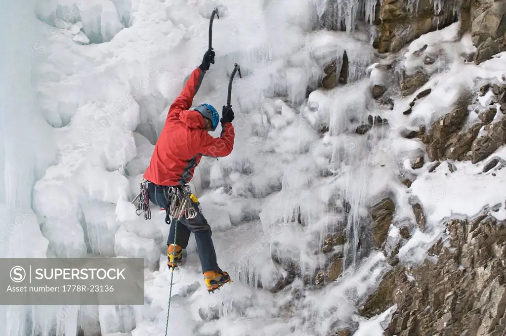 A man ice climbing a frozen waterfall, Silverton, Colorado.