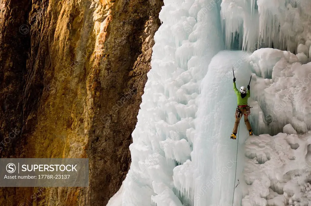 A woman ice climbing a frozen waterfall, Silverton, Colorado.
