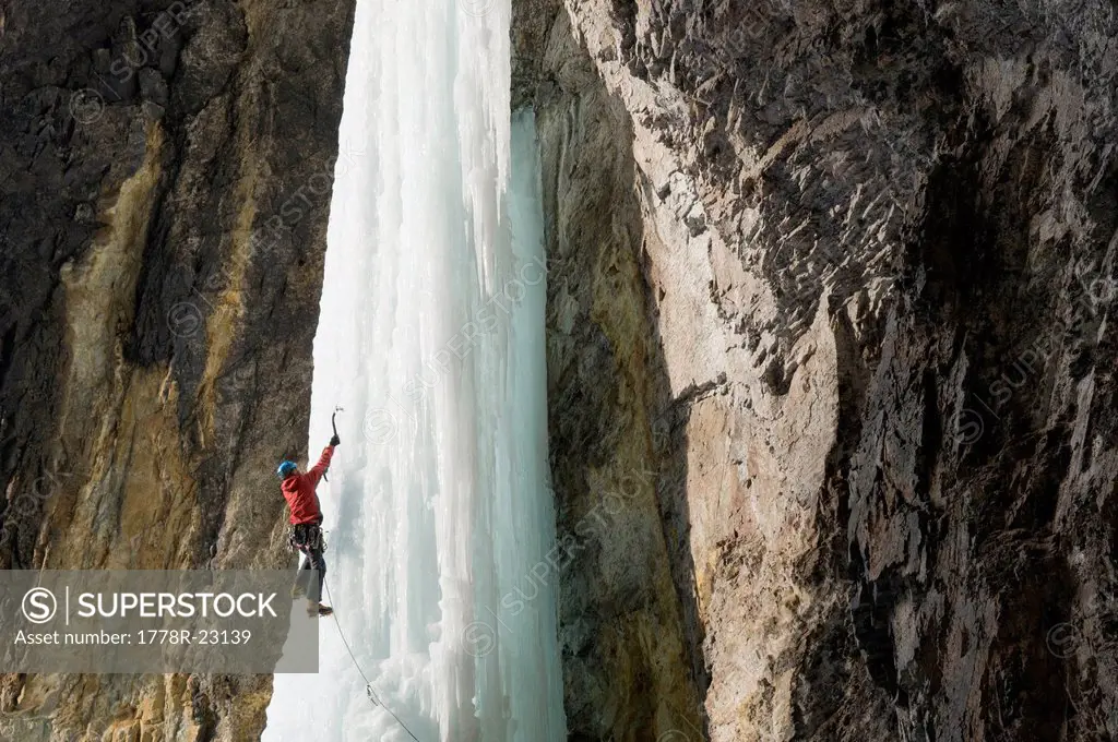 A man ice climbing a frozen waterfall, Silverton, Colorado.