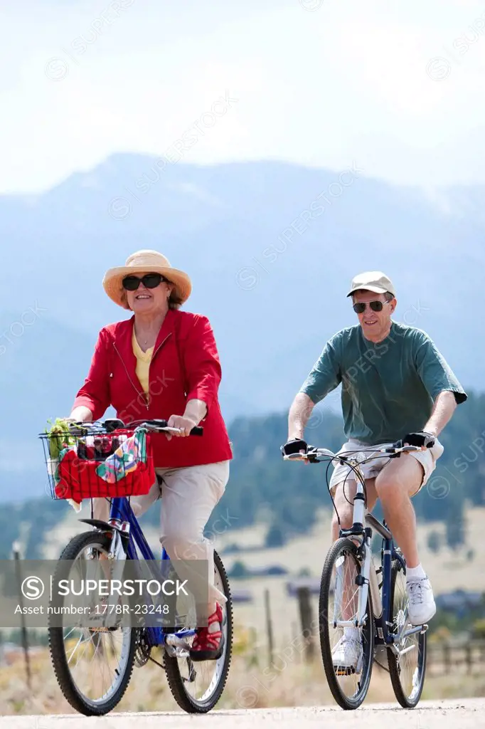 An older couple enjoys biking on a dirt road in Estes Park, Colorado.