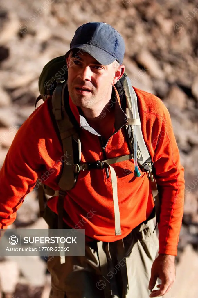 A man hikes a rocky peak in Colorado.