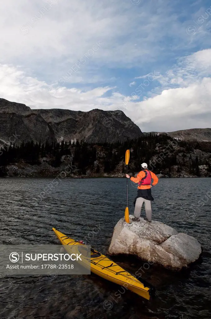 A man sea kayaking on Lake Marie in the Medicine Bow Mountains near Centennial, Wyoming.