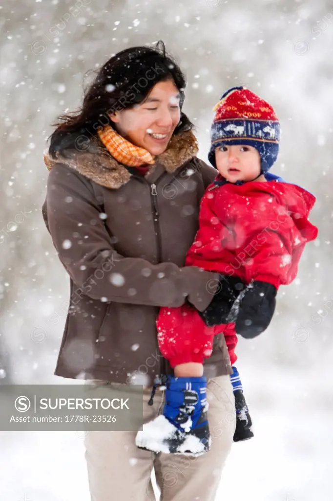 A mother plays with her toddler son in his first big snowstorm in Fort Collins, Colorado.