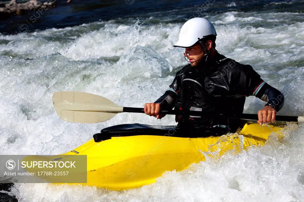 A male kayaker in a playboat paddles on the Clark Fork River, Missoula, Montana.