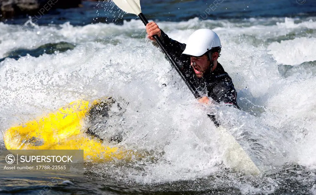 A male kayaker in a playboat battles the rapids of Brennan´s Wave, Missoula, Montana.