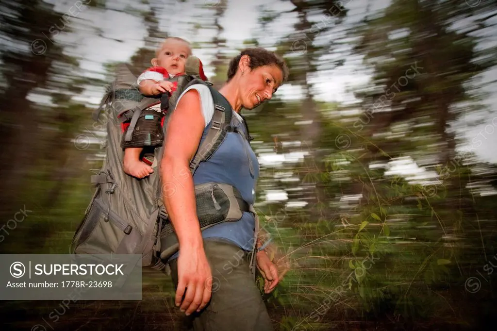 A woman carries her child in a backpack, Hinchinbrook Island, Queensland, Australia.