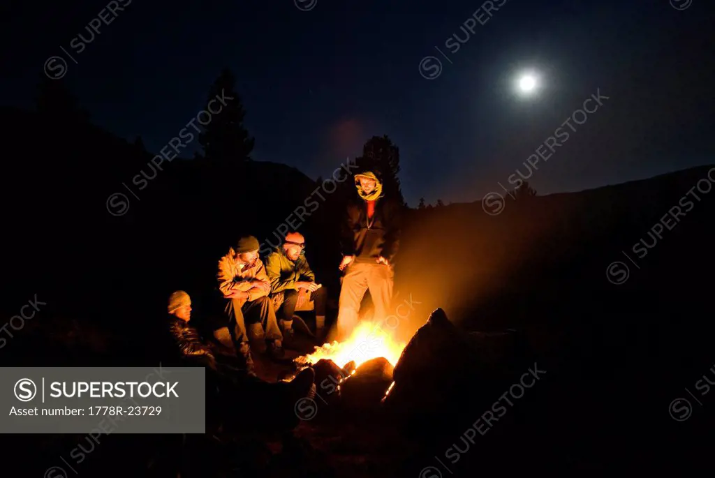 A group of campers sit around a camp fire for warmth in Yosemite, California.