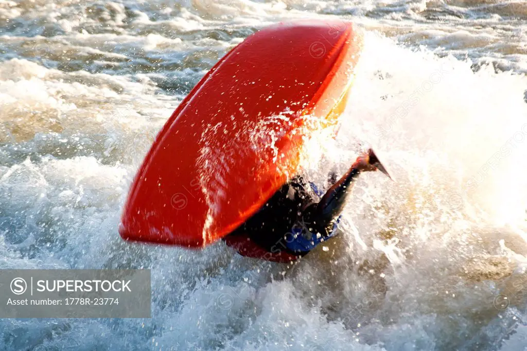 A kayaker does a back flip off Brennan´s Wave on the Clark Fork River, Missoula, Montana.