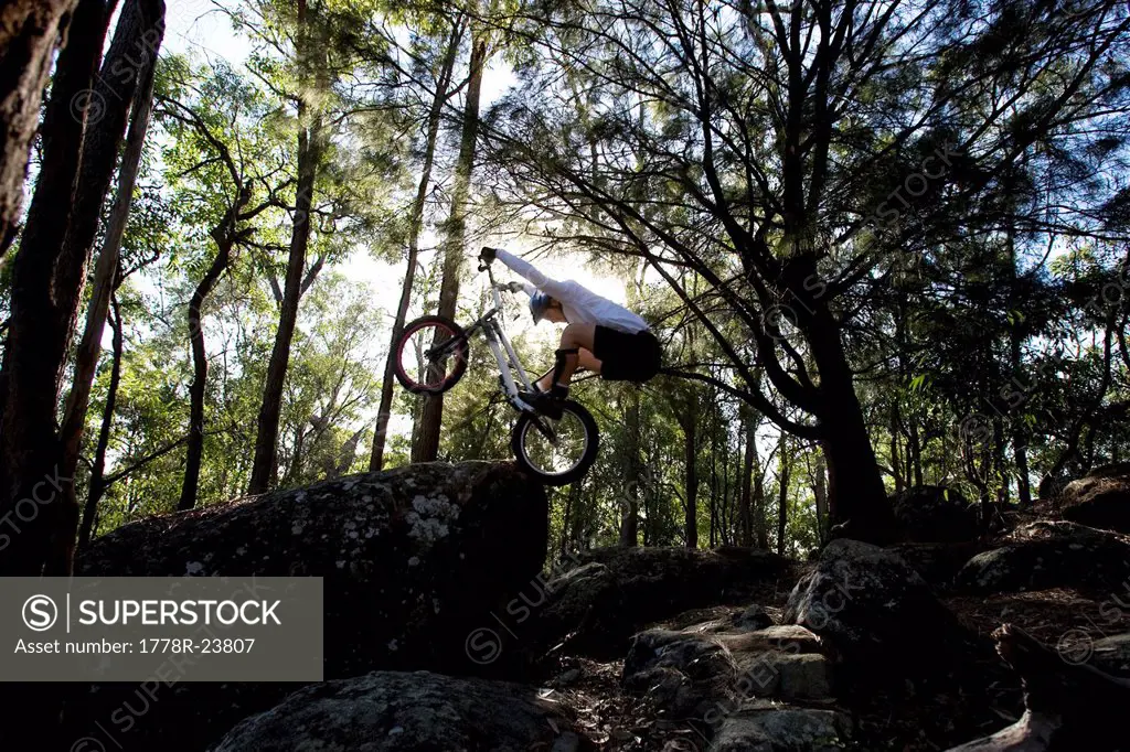 A Trials rider leaps onto a rock at Toohey Forest, Brisbane, Queensland, Australia.