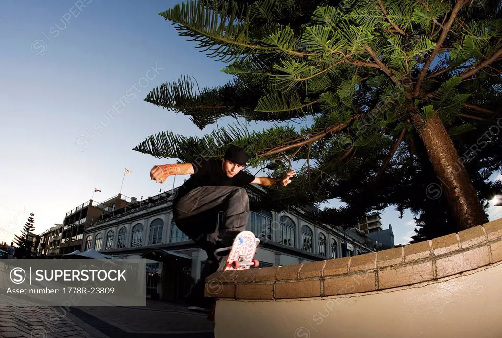A skateboarder slides the pavement along a bench at Clovelly, New South Wales, Australia.