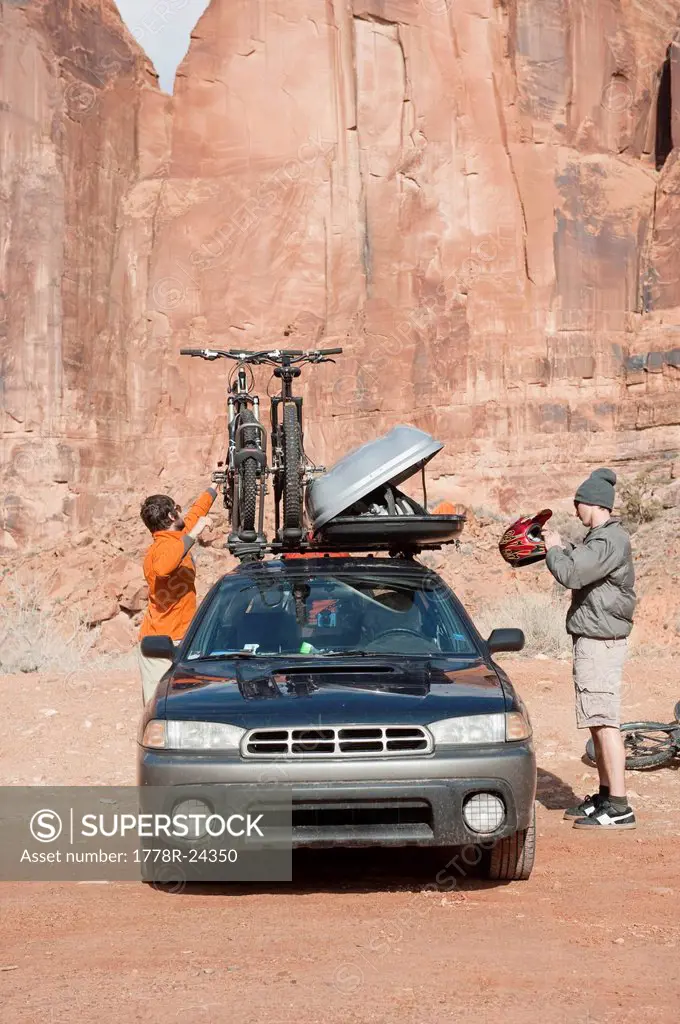 Two young men unloading their equipment before going mountain biking in Moab, UT.